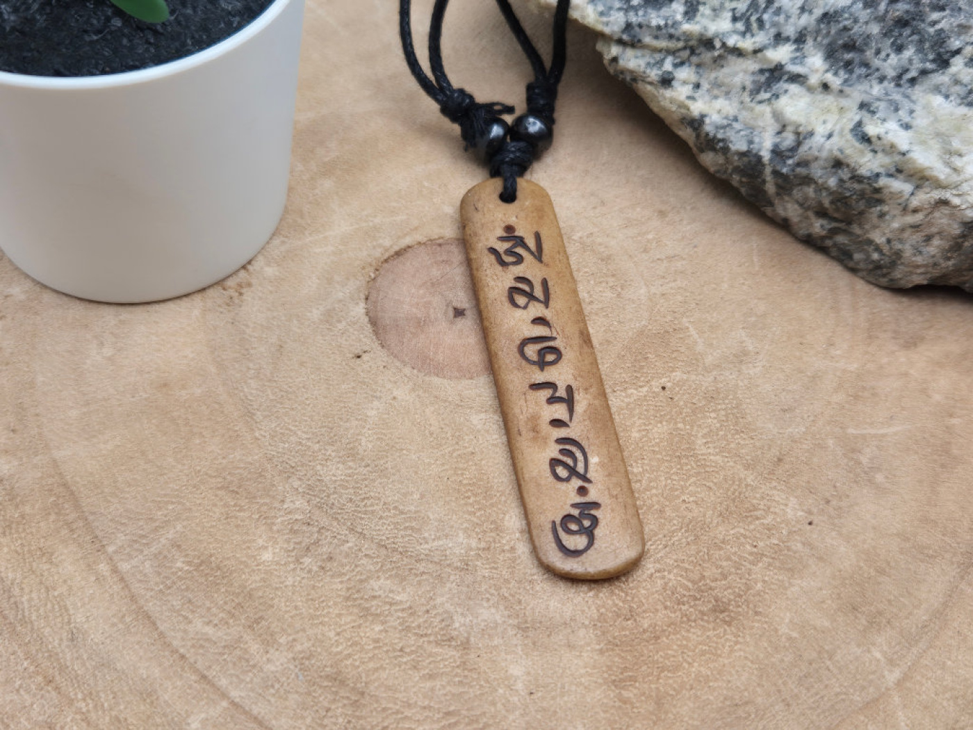 Brauner Knochenanhänger mit tibetischem Mantra Om Mani Padme Hum an schwarzem Band – Handarbeit aus Nepal